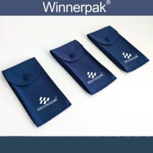 Winnerpak three navy blue suede jewelry pouches arranged diagonally in ascending order. Premium microfiber suede material with fabric-covered snap button closure, white Winnerpak logo with four tilted squares graphic. Wholesale jewelry packaging from Guangzhou manufacturer.